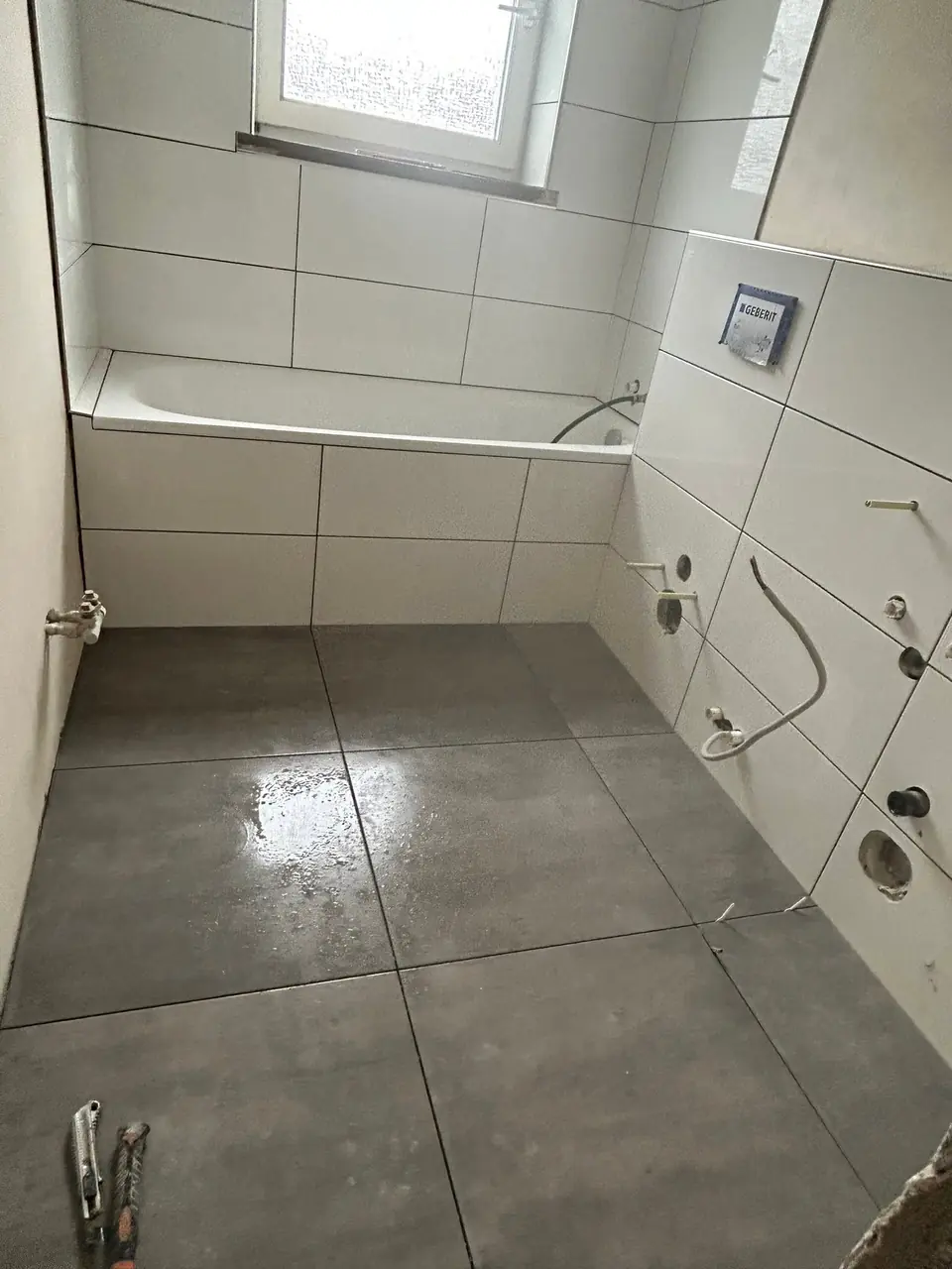 Bad mit Wanne und großformatigen Wand- und Bodenfliesen