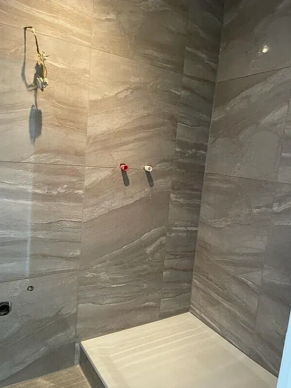 Sanierte Dusche mit großformatigen Fliesen in Steinoptik
