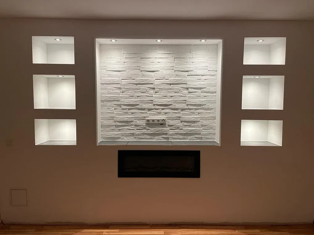 Beleuchtete TV-Wand mit Nischen, Steinoptik und Elektrokamin